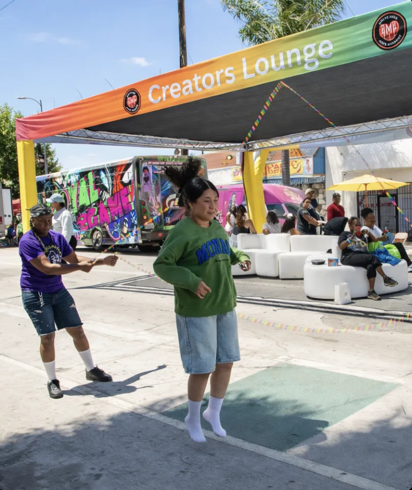 Creators Lounge activation with rainbow canopy and attendees jumping rope